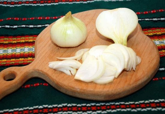 Репчатый лук на деревянной разделочной доске
